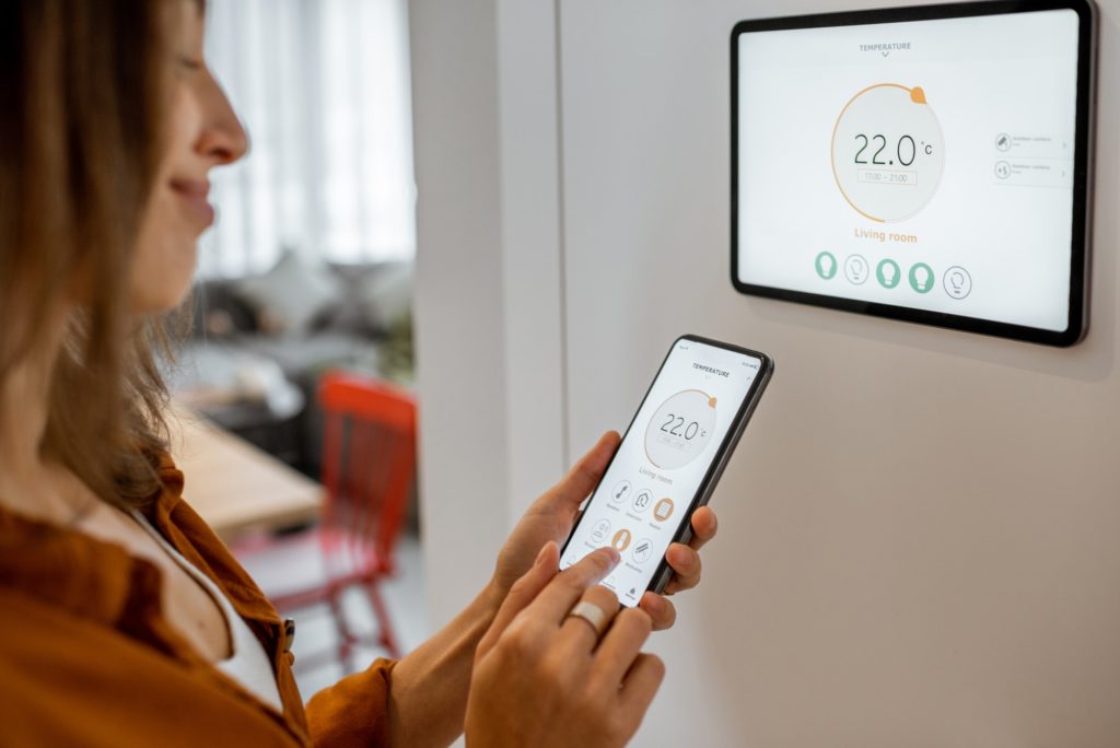 Woman controlling heating with a smart devices