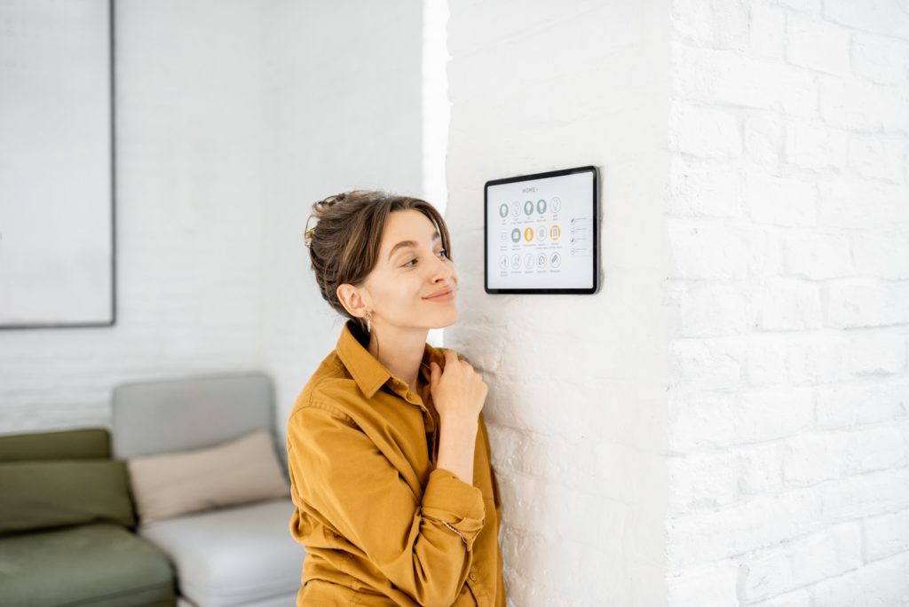 Woman controlling home with a digital touch screen
